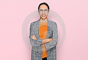 Young hispanic girl wearing business jacket and glasses happy face smiling with crossed arms looking at the camera