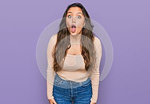 Young hispanic girl wearing casual clothes afraid and shocked with surprise expression, fear and excited face