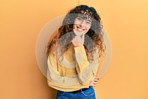 Young hispanic girl wearing casual clothes looking confident at the camera smiling with crossed arms and hand raised on chin