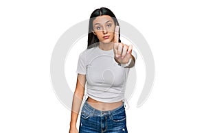 Young hispanic girl wearing casual white t shirt pointing with finger up and angry expression, showing no gesture