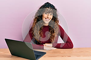 Young hispanic girl working using computer laptop with a happy and cool smile on face