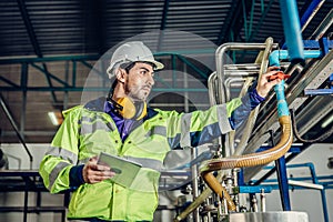 Young hispanic latin engineer working in a heavy industrial factory. worker control oil gas water pipe in plant