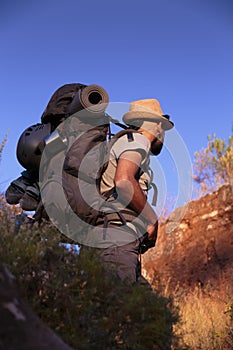 Young hispanic male hiker admires nature as he walks