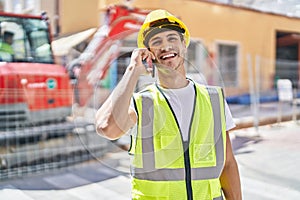 Young hispanic man architect smiling confident talking on smartphone at park