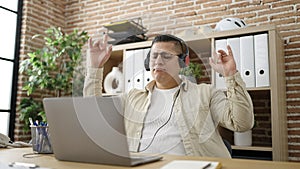 Young hispanic man business worker dancing using laptop at office