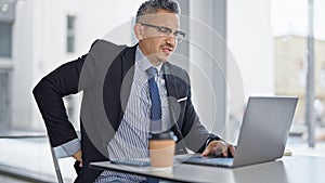 Young hispanic man business worker suffering for backache at office