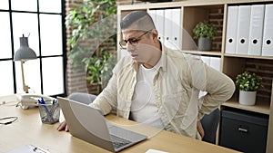 Young hispanic man business worker suffering for backache at office