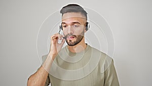 Young hispanic man call center agent wearing headset working over isolated white background