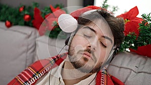 Young hispanic man celebrating christmas sleeping on sofa at home