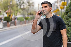 Young hispanic man with a dark complexion talking with the smartphone