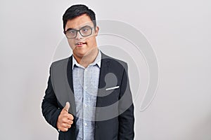 Young hispanic man with down syndrome wearing business style doing happy thumbs up gesture with hand