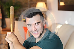 Young Hispanic man holding a baseball bat