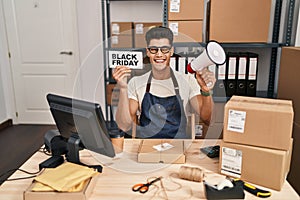 Young hispanic man holding black friday banner small commerce winking looking at the camera with sexy expression, cheerful and