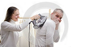 Young hispanic man ironing clothes at home pointing to the back behind with hand and thumbs up, smiling confident