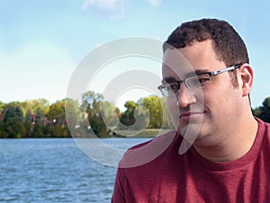 Young Hispanic man by lake