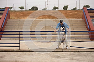 Young Hispanic man, leaning on a railing next to his dog in a funny attitude. Concept, dogs, pets, animals, friends