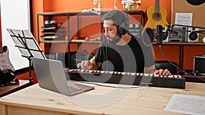 Young hispanic man musician having online piano lesson at music studio
