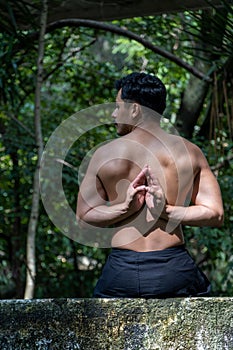 Young Hispanic man practicing Vajrasana yoga pose in the forest in Mexico, Guadalajara