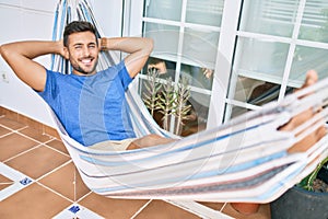 Young hispanic man relaxed smiling happy lying on the hammock at terrace