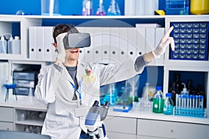 Young hispanic man scientist using virtual reality glasses at laboratory