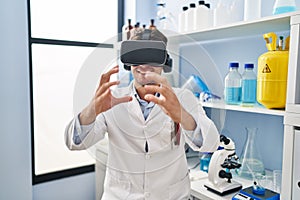 Young hispanic man scientist using virtual reality glasses at laboratory