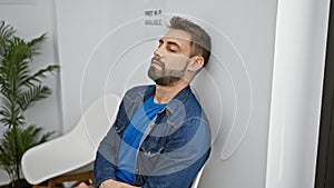 Young hispanic man sitting on chair sleeping at waiting room