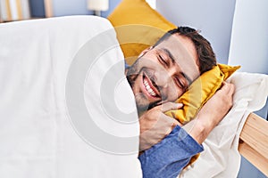 Young hispanic man sleeping on bed at bedroom