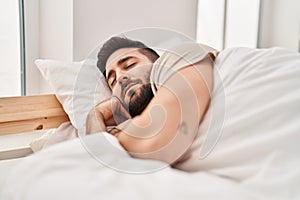 Young hispanic man sleeping on bed at bedroom