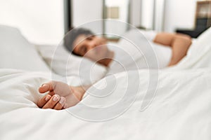 Young hispanic man sleeping lying on the bed at bedroom