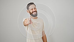 Young hispanic man smiling confident pointing to camera winking eye over isolated white background