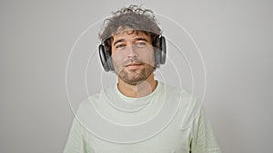 Young hispanic man smiling confident wearing headphones over isolated white background