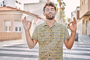 Young hispanic man standing at the street relax and smiling with eyes closed doing meditation gesture with fingers