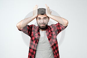 Young hispanic man is surprised with hand on head for mistake, remember error