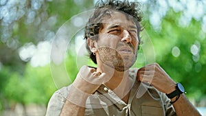 Young hispanic man sweating at park