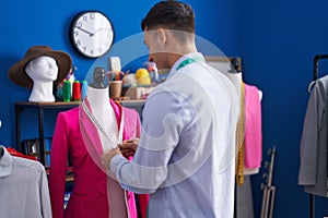 Young hispanic man tailor smiling confident measuring jacket at sewing studio