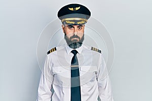 Young hispanic man wearing airplane pilot uniform depressed and worry for distress, crying angry and afraid