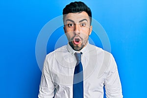 Young hispanic man wearing business clothes afraid and shocked with surprise expression, fear and excited face