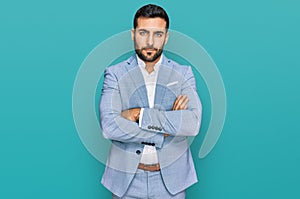 Young hispanic man wearing business jacket skeptic and nervous, disapproving expression on face with crossed arms photo