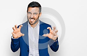 Young hispanic man wearing business jacket smiling funny doing claw gesture as cat, aggressive and sexy expression