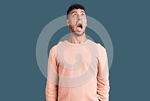 Young hispanic man wearing casual clothes angry and mad screaming frustrated and furious, shouting with anger