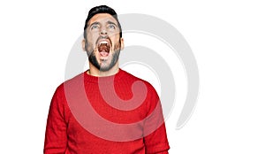 Young hispanic man wearing casual clothes angry and mad screaming frustrated and furious, shouting with anger