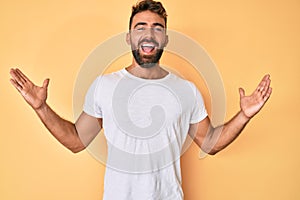 Young hispanic man wearing casual clothes celebrating victory with happy smile and winner expression with raised hands