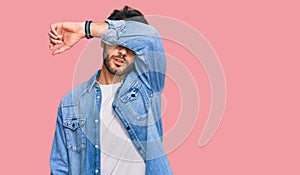 Young hispanic man wearing casual clothes covering eyes with arm, looking serious and sad