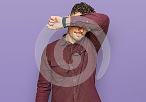 Young hispanic man wearing casual clothes covering eyes with arm, looking serious and sad