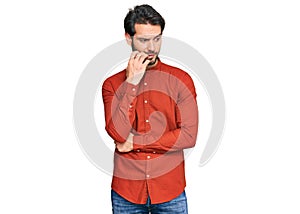 Young hispanic man wearing casual clothes looking stressed and nervous with hands on mouth biting nails