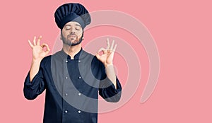 Young hispanic man wearing cooker uniform relax and smiling with eyes closed doing meditation gesture with fingers