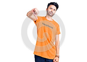 Young hispanic man wearing t shirt with happiness word message looking unhappy and angry showing rejection and negative with