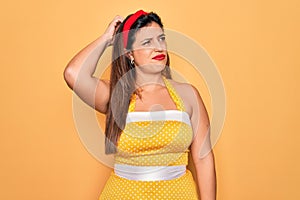 Young hispanic pin up woman wearing fashion sexy 50s style over yellow background confuse and wondering about question