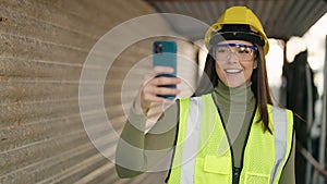 Young hispanic woman architect having video call at construction site