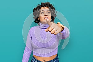 Young hispanic woman with curly hair wearing casual clothes pointing displeased and frustrated to the camera, angry and furious